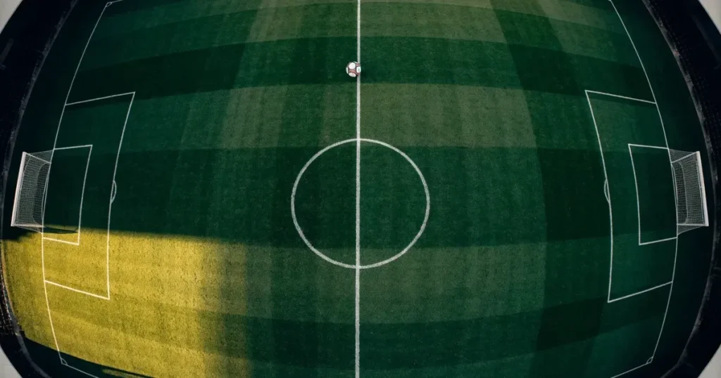Ein Spielfeld aus der Vogelperspektive mit frisch gezogenen weißen Linien, ein einzelner Ball liegt im Strafraum, niemand ist zu sehen.